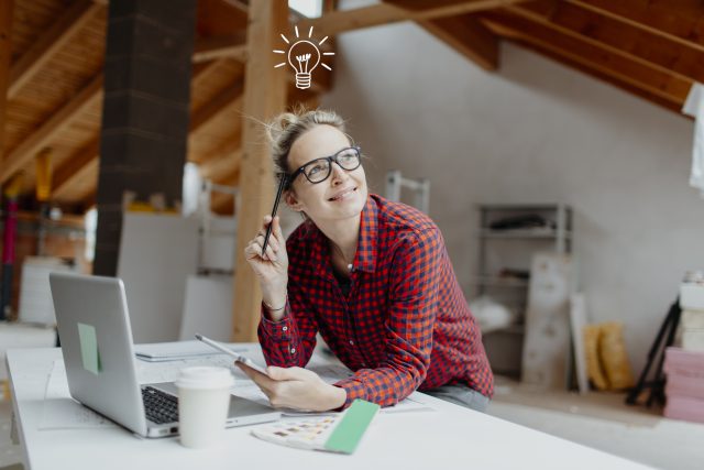 young, pretty, blonde woman is planning on the notebook and tablet the expansion of her loft and a light goes on her