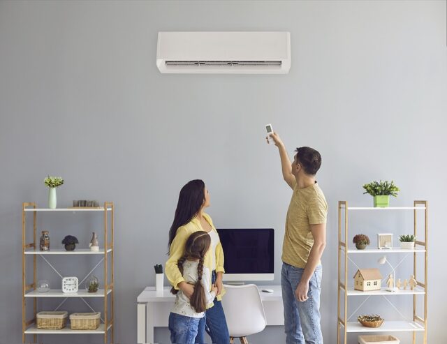 The Family Uses Air Conditioning At Home. Back View.