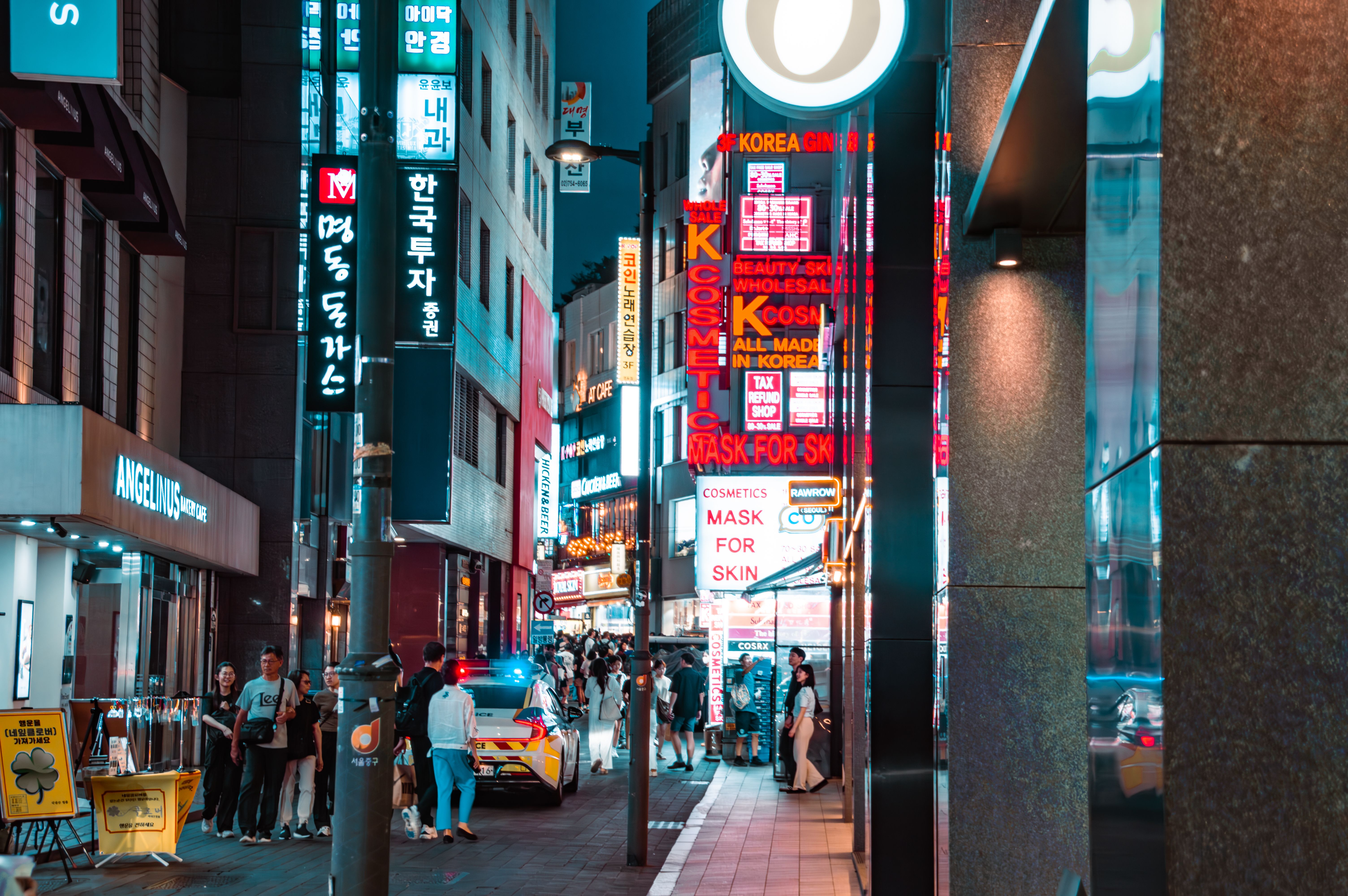 Bustling Myeongdong street in Seoul at night, filled with bright signs and nightlife activity.