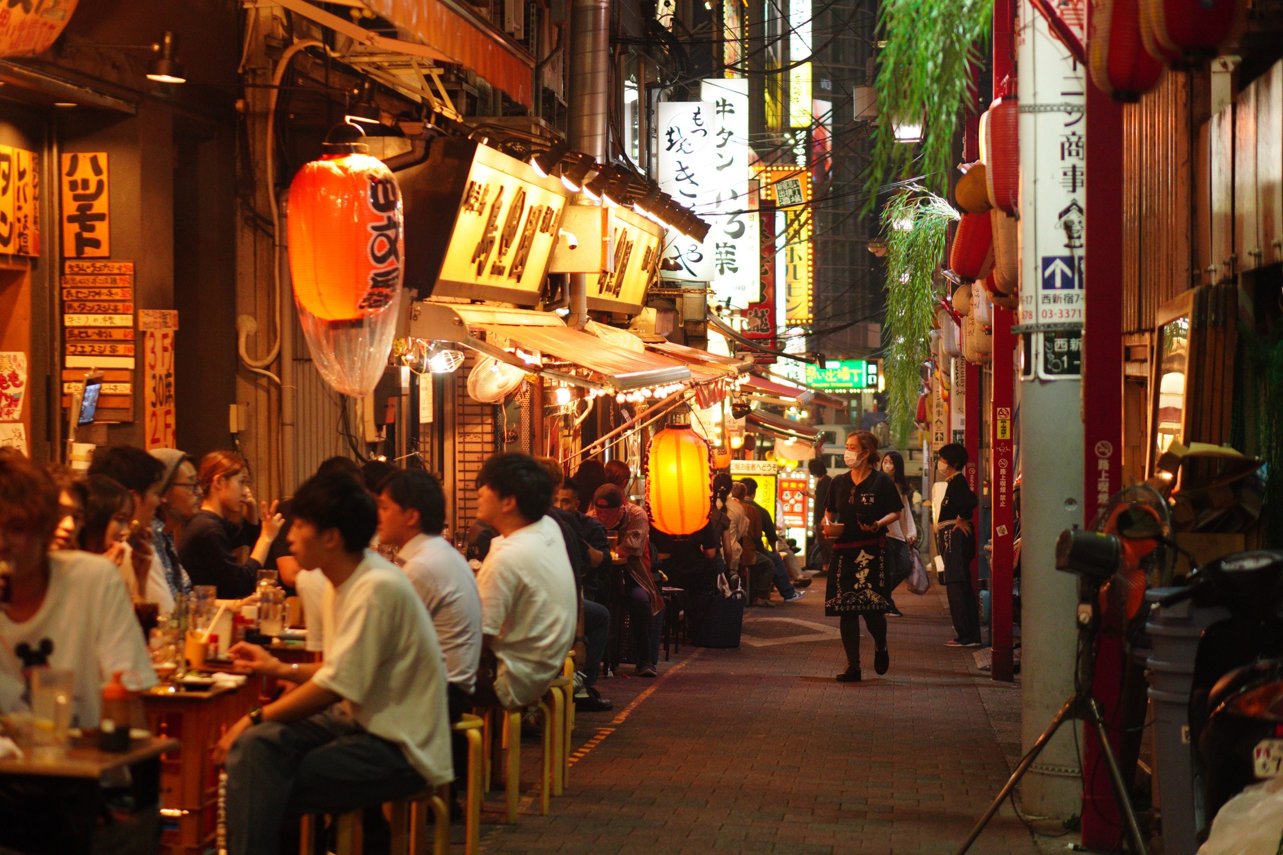 Best Asian Cities for Nightlife, Dining and Late-Night Entertainment in 2027 Lively nighttime dining alley in Shinjuku, Tokyo, illuminated by Japanese paper lanterns.